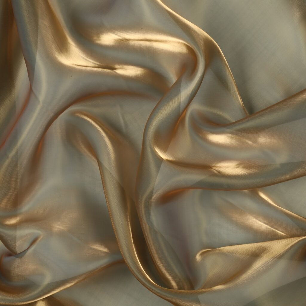 Dettaglio organza lucida ottone - trasparenza e riflessi